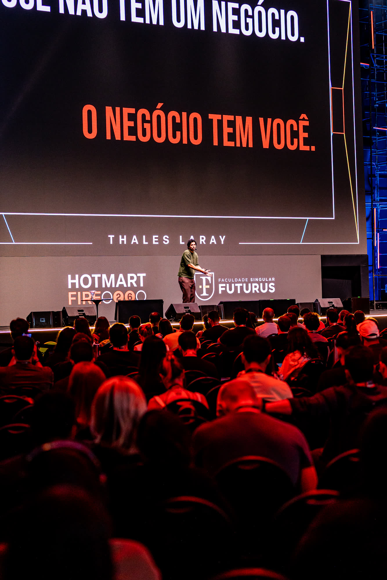 Telão com a frase o negócio tem você, Thales no palco