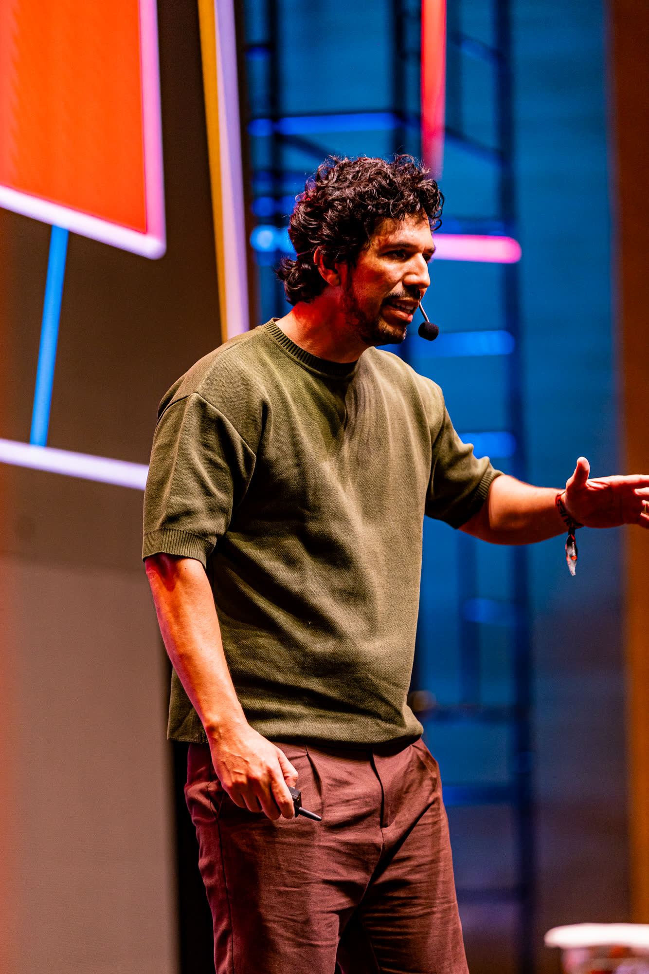 Thales Laray de microfone no palco, diante do telão